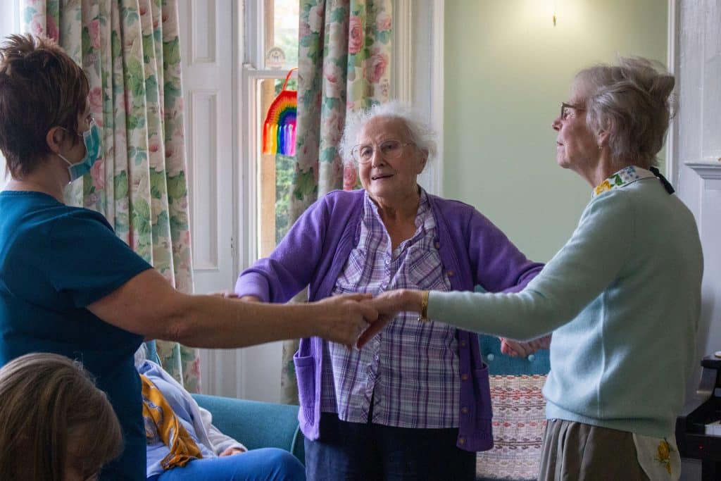 Residents and a team member enjoying some dancing in the Featherton House Care Home lounge.