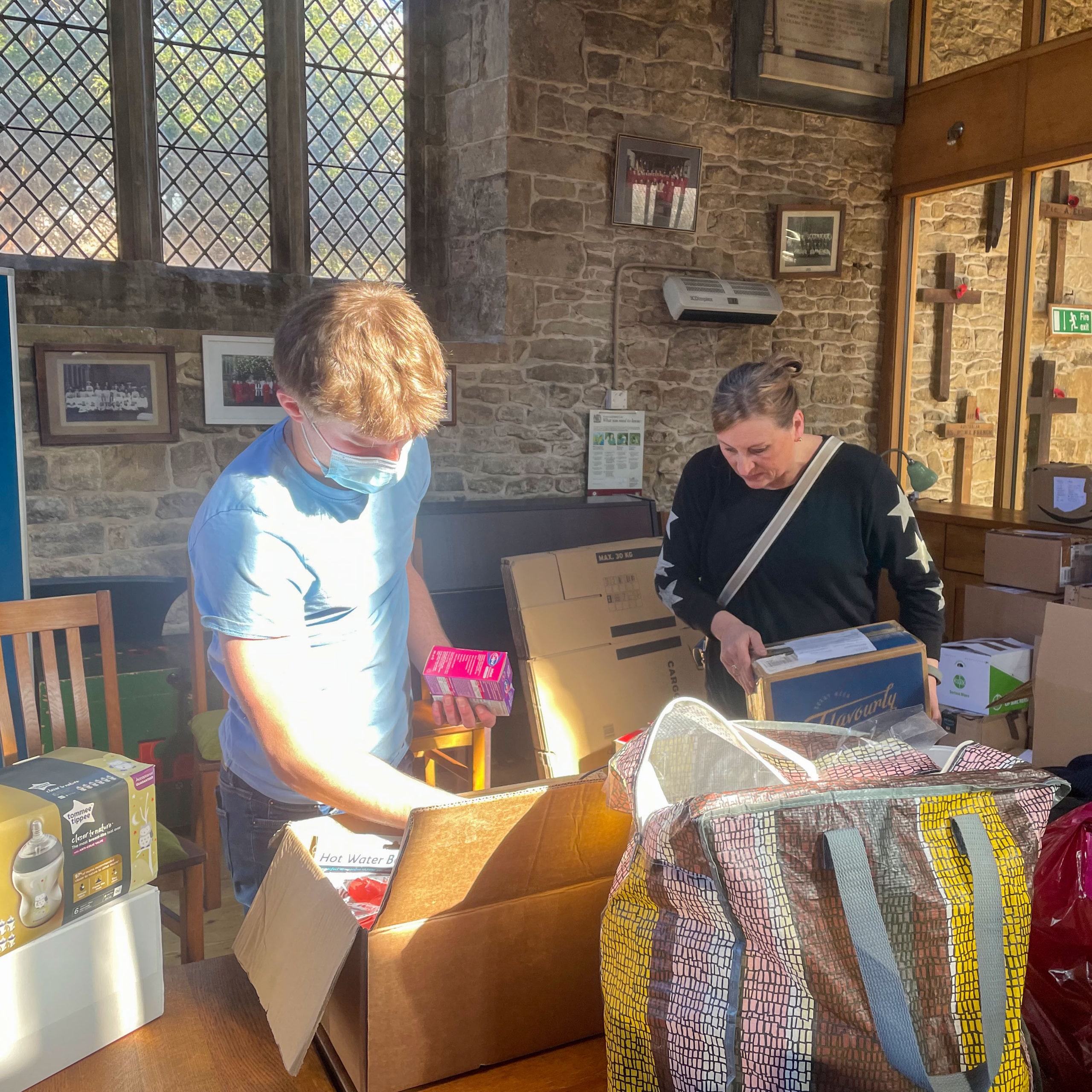 Deddington resident Fynn Watt and his mother sorting and packing items at the village collection hub for the people of Ukraine.