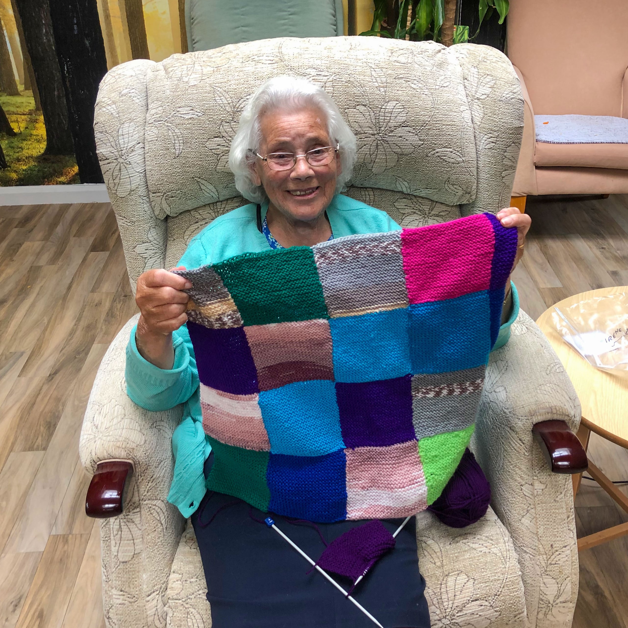 A resident of Linden House Care Home in Epsom with a blanket knitted for their blankets for Battersea appeal.
